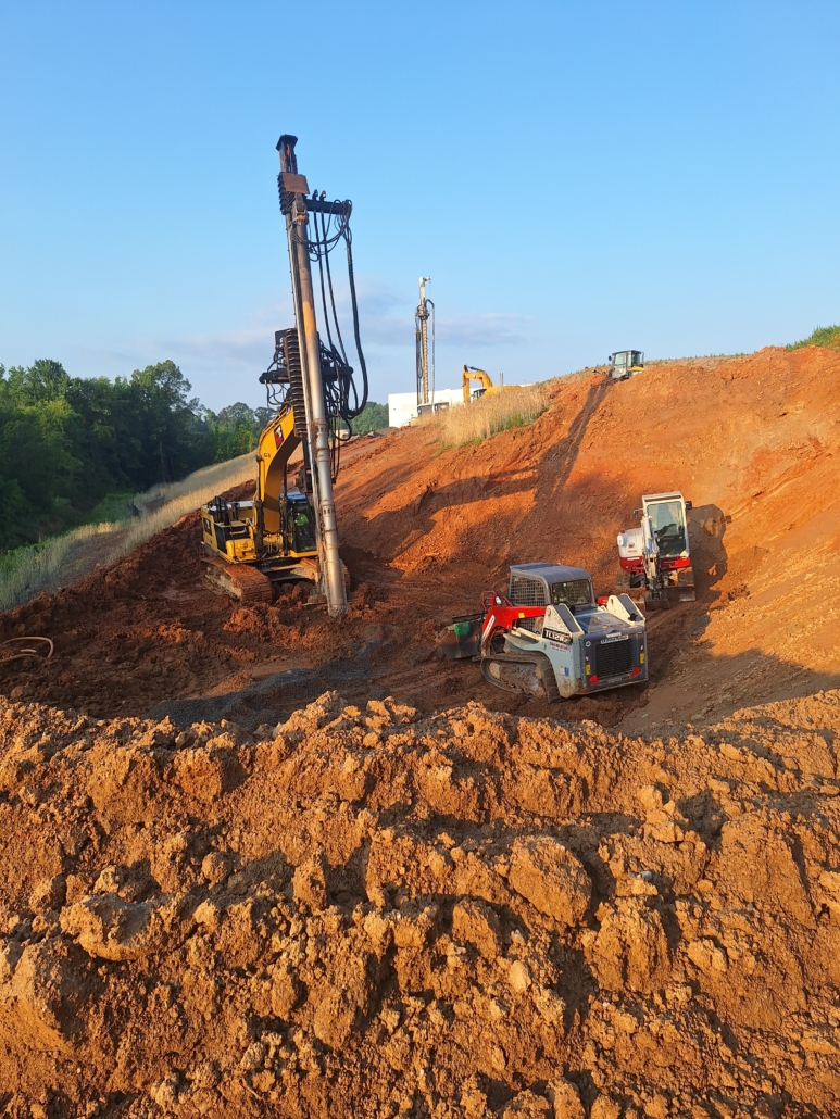 GastonCommerce_Aggregate Pier_Rigid Inclusion_CNCFoundations2 CNC Foundations crew installing aggregate piers on a steep slope using Soilmec equipment and tracked loaders in Gastonia, NC. Ground improvement methods stabilize soils for a 280,000 SF industrial logistics facility.