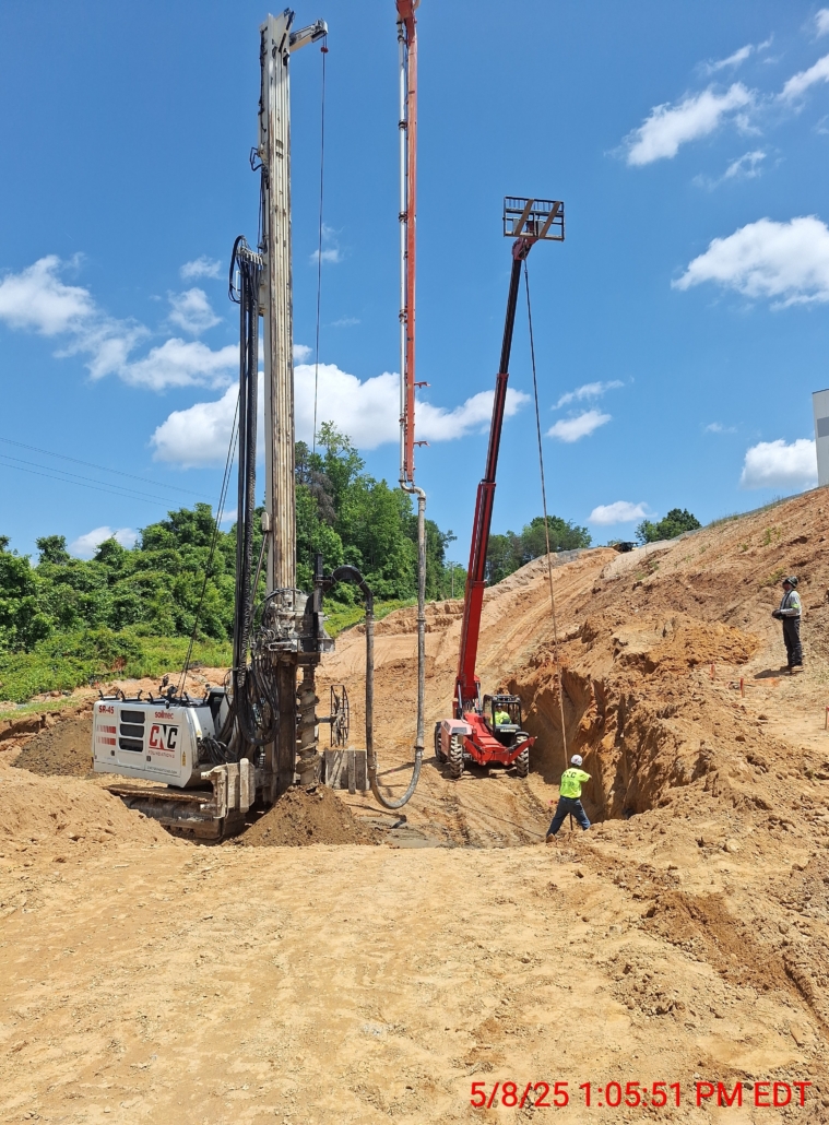 GastonCommerce_Aggregate Pier_Rigid Inclusion_CNCFoundations3 Close-up of CNC Foundations rigid inclusion installation with a Soilmec SR-45 rig, concrete pump line, and safety personnel on site in Gastonia, NC. Deep foundation drilling enhances soil bearing capacity.