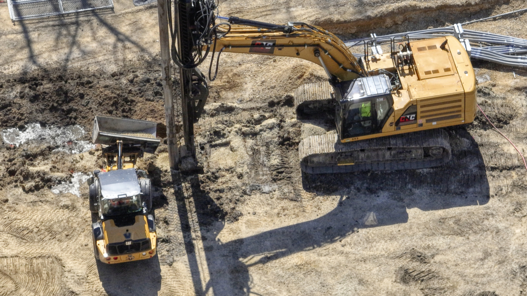 Overhead view of CNC Foundations excavator and loader installing grouted aggregate piers at the Queen Marquette Casino expansion site in Iowa, showcasing precision ground improvement in challenging soil conditions.