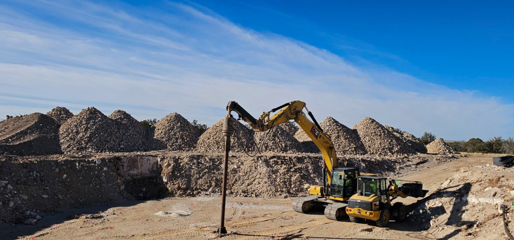 CNC Foundations installing aggregate piers at SunZia Wind Farm using CAT excavators, with gravel piles in the background—part of a subsurface stabilization effort supporting wind turbine foundations in New Mexico.