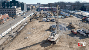 delmar loop_cnc foundations_AGGREGATE PIER INSTALLATION Aerial view of CNC Foundations' job site in the Delmar Loop, showing active aggregate pier installation across a large urban lot. The CNC drill rig, multiple pieces of construction equipment, and surrounding city buildings are visible on a clear day.