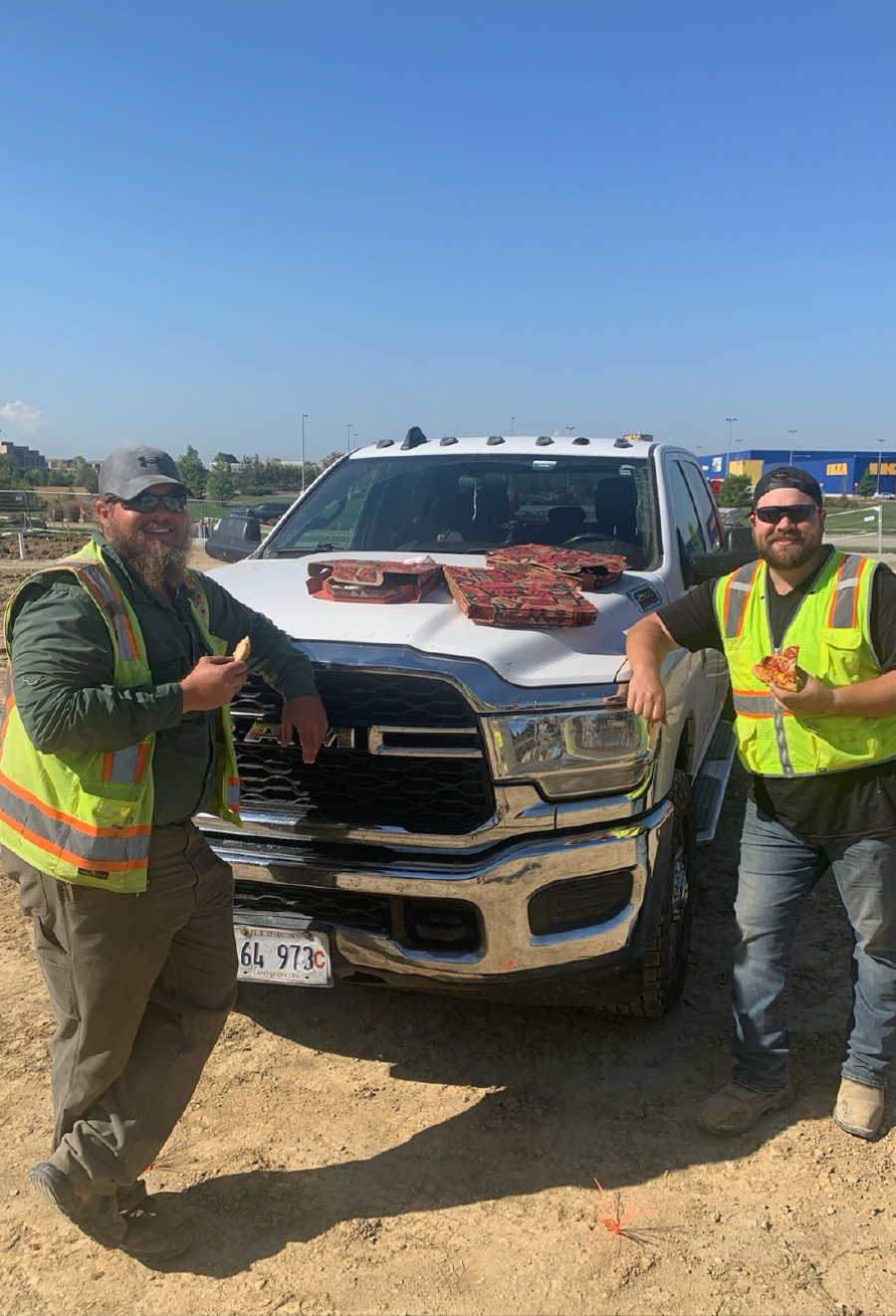 CNC crew members beside a company truck on a jobsite